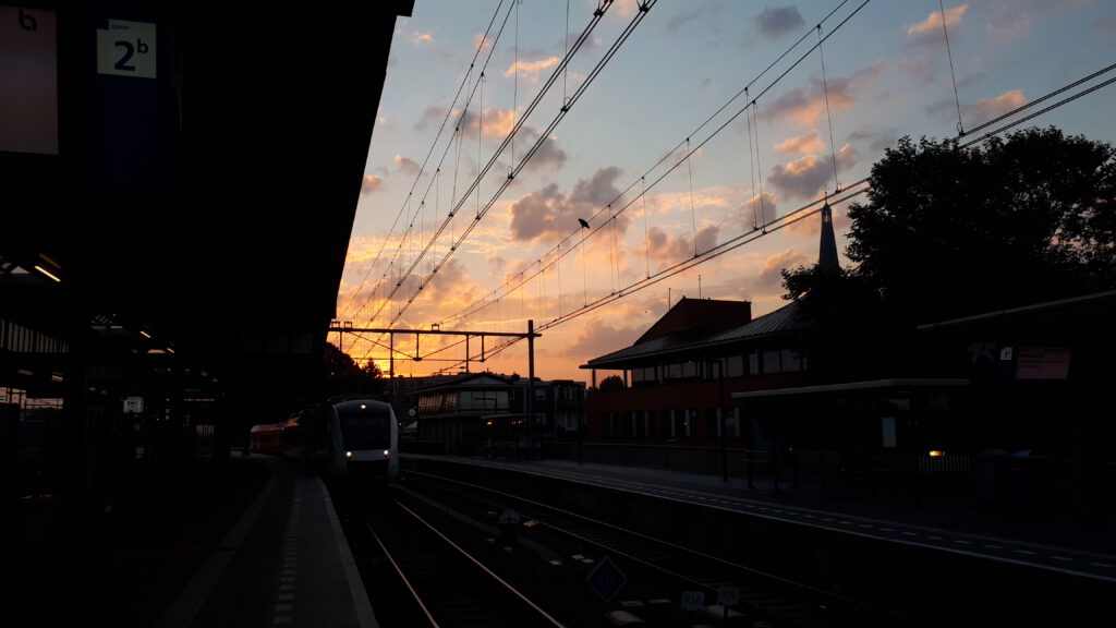De trein naar Hengelo komt het station van Zutphen inrijden met een mooie ochtendlucht.